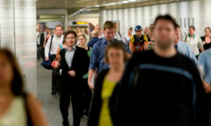 A crowd walking through a Merseyrail station. 